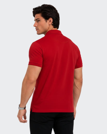 Sman men's premium red half-sleeve polo t shirt shown from a three-quarters back view. The image highlights the tailored fit, clean back drape, and subtle side hem slits, modeled with black denim jeans against a minimalist light gray studio background.